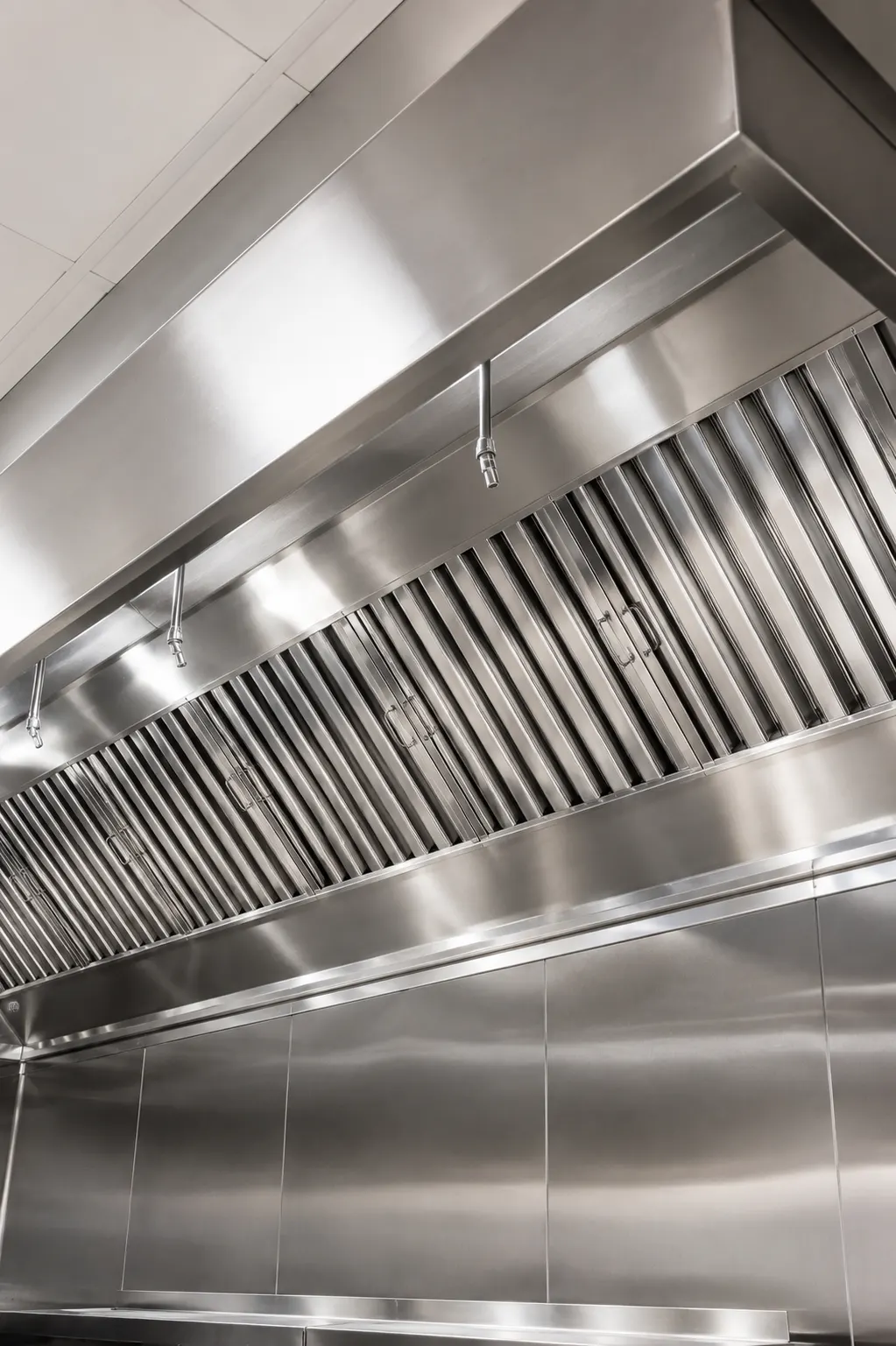 A commercial kitchen extraction hood with clean stainless baffle filters